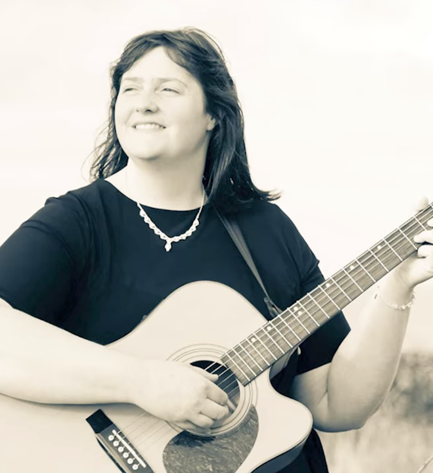 Bridgeen McNicholl, founder of Ruah, holding an acoustic guitar