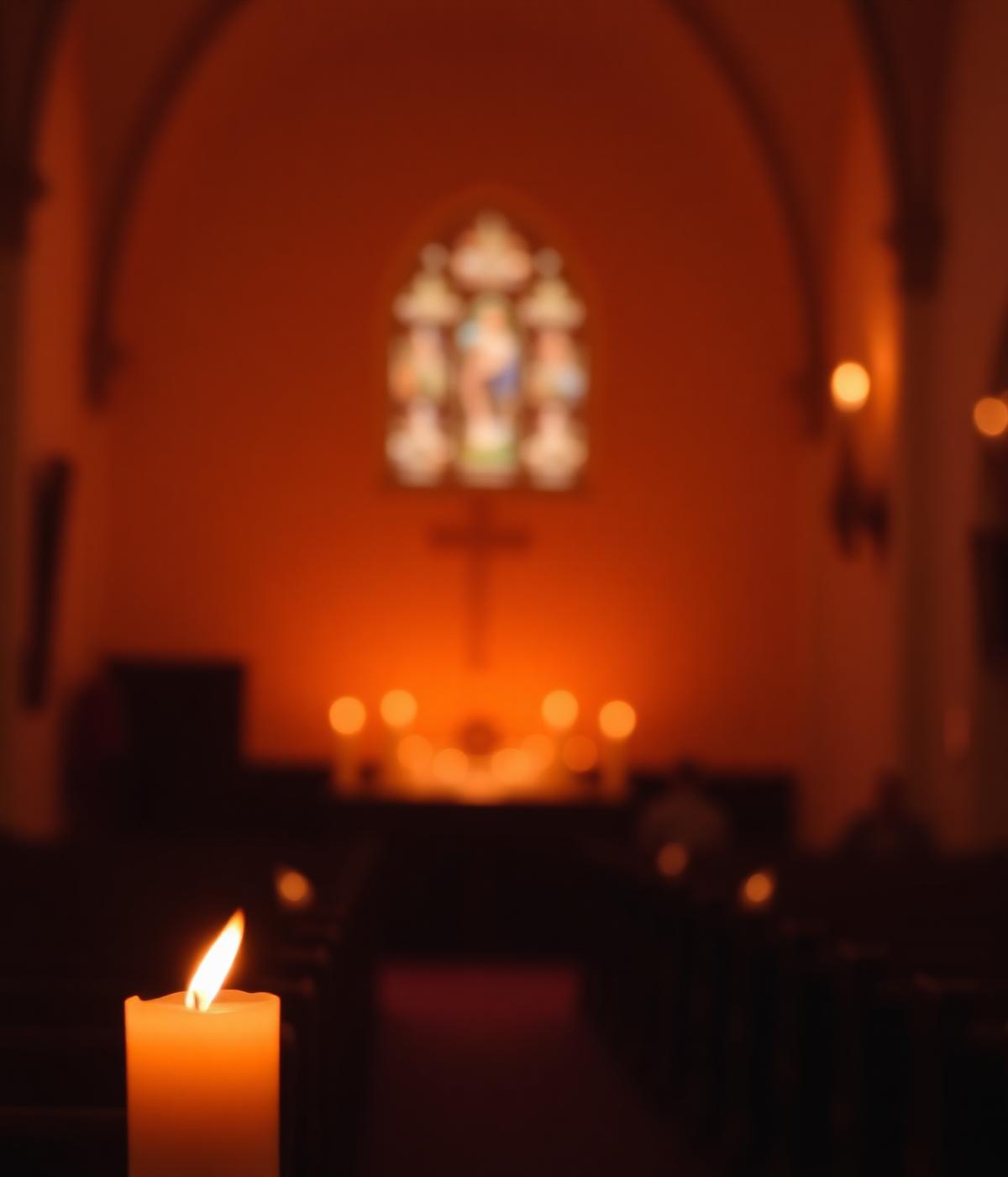 Candle glowing inside a quiet chapel